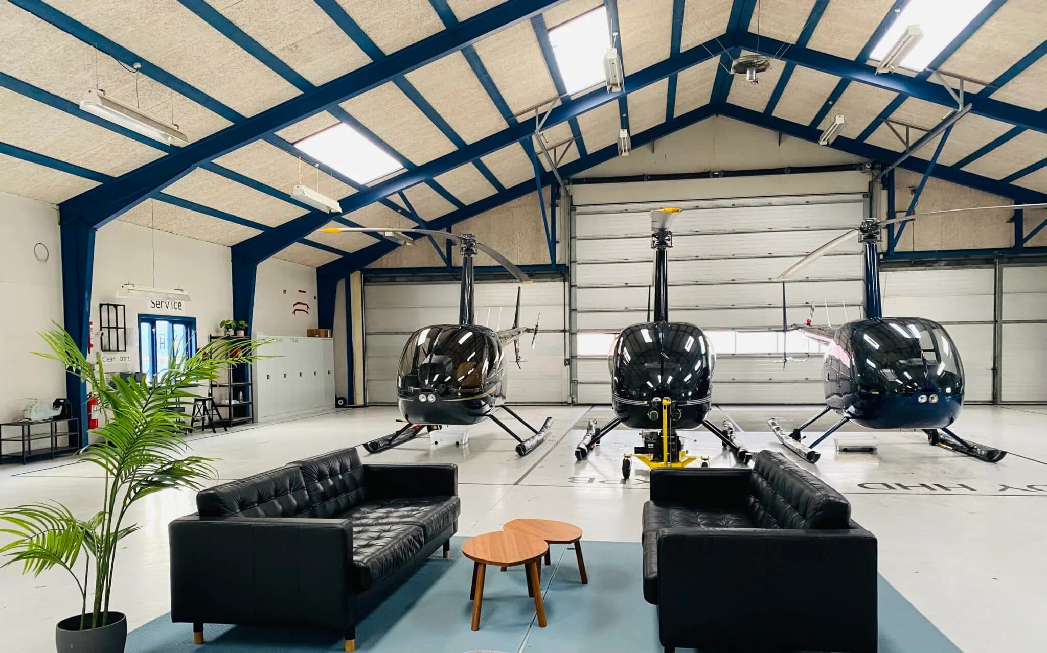 HeliClubs lokaler i hangaren med sofaer og helikoptere