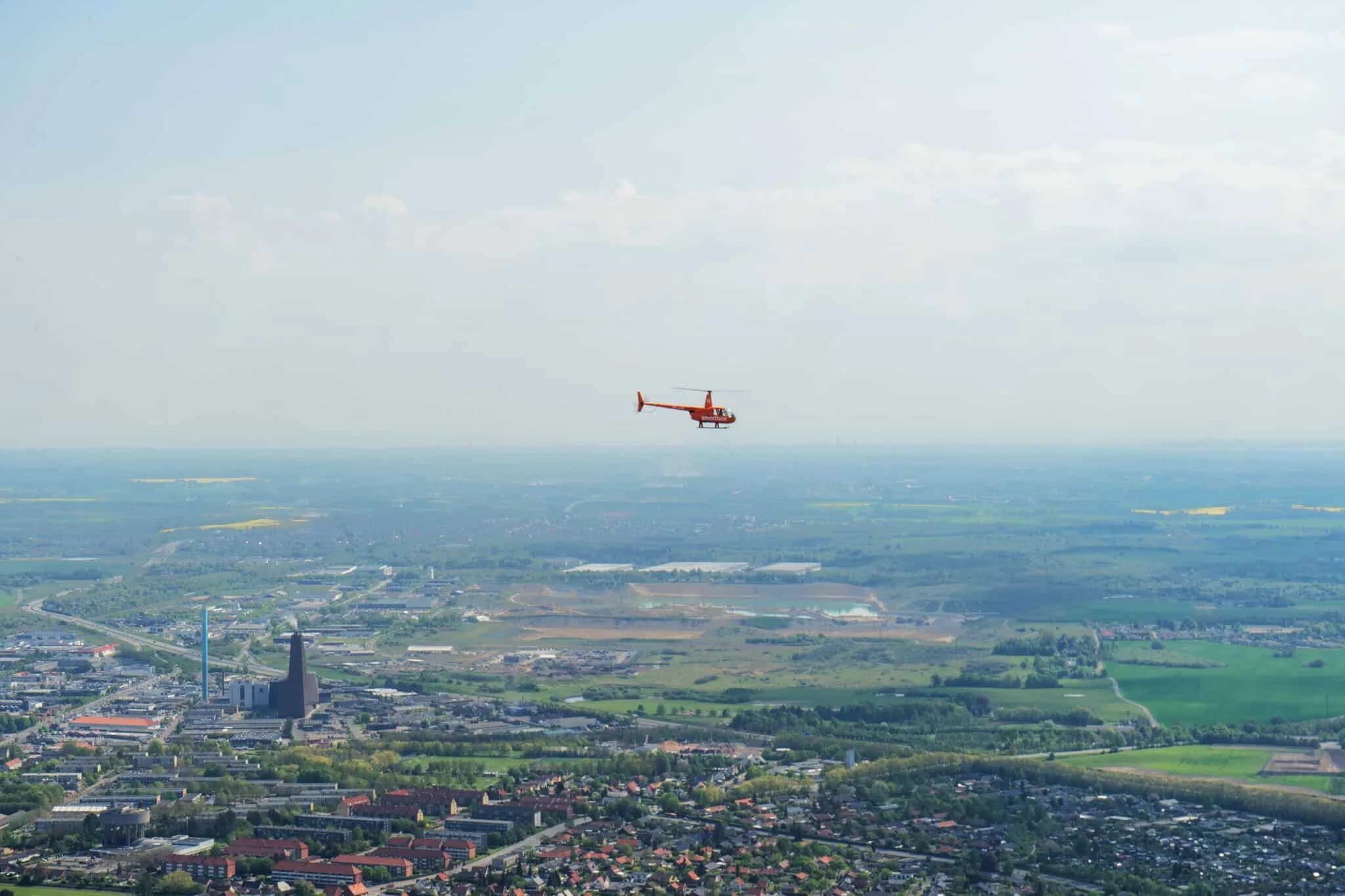 En helikopter højt over en by og det åbne land