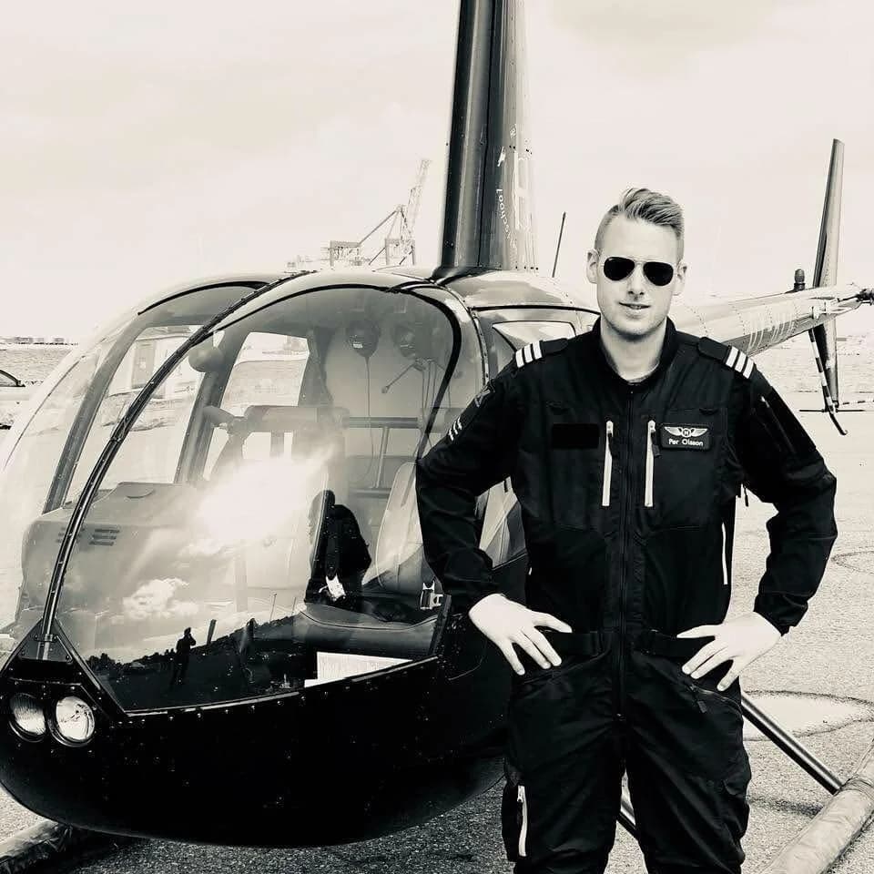 En pilot i uniform ved helikopteren