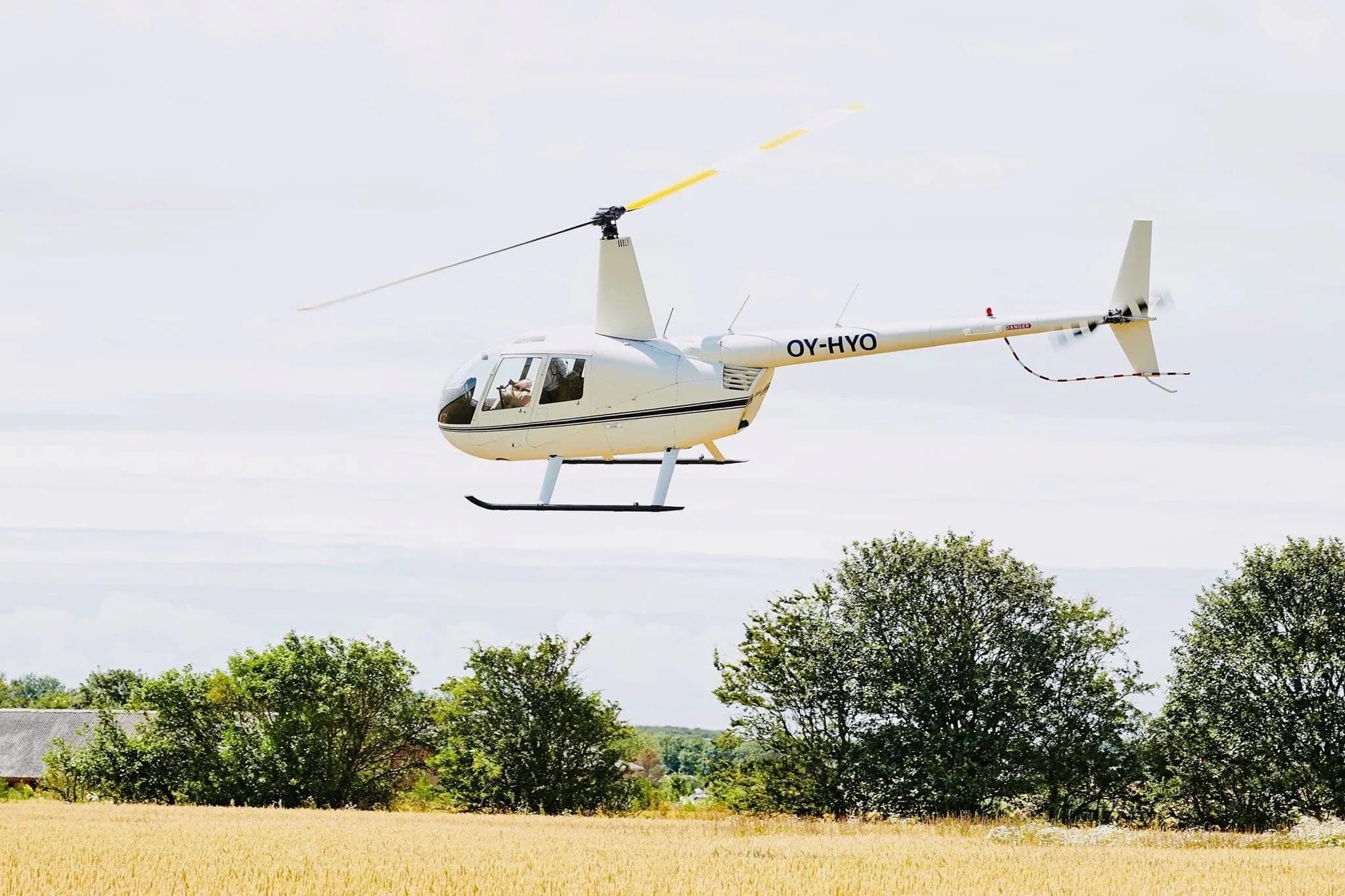 En hvid helikopter over træerne